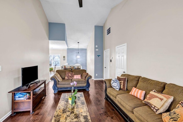 living room with a high ceiling and dark hardwood / wood-style flooring