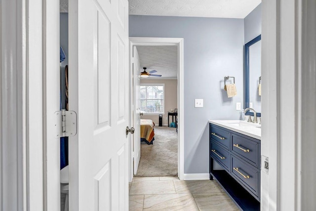 bathroom featuring vanity, ceiling fan, and a textured ceiling