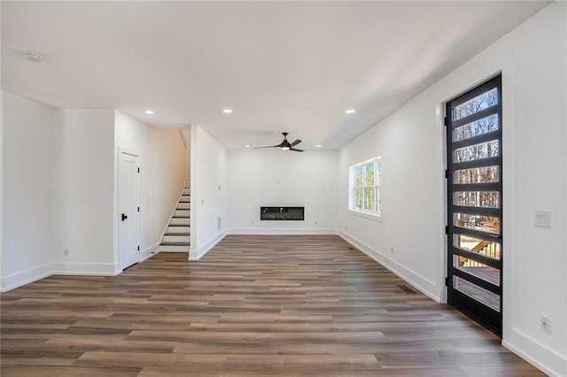 unfurnished living room featuring a fireplace, recessed lighting, stairway, a ceiling fan, and wood finished floors