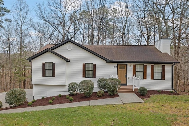 ranch-style house with roof with shingles, a chimney, and a front yard