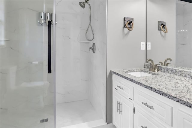 full bathroom with vanity and a marble finish shower