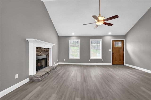 unfurnished living room featuring a stone fireplace, wood finished floors, and baseboards