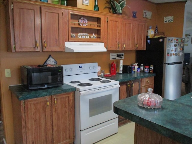 kitchen featuring stainless steel refrigerator and white range with electric cooktop