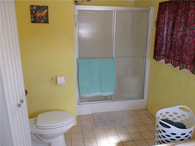 bathroom with toilet and a shower with shower door