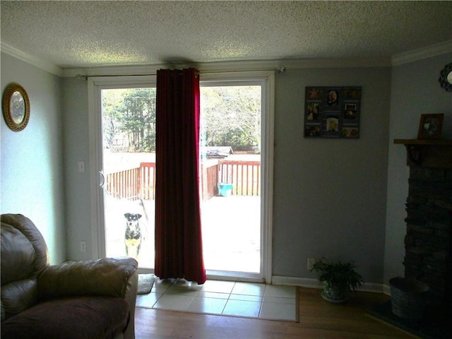 doorway with light hardwood / wood-style flooring, ornamental molding, and a textured ceiling