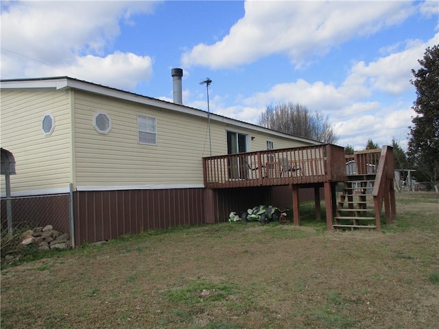 back of house with a deck and a lawn