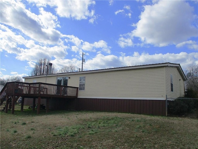 view of home's exterior featuring a wooden deck and a lawn