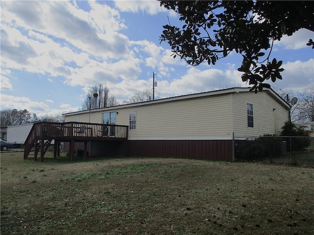 rear view of house featuring a yard and a deck