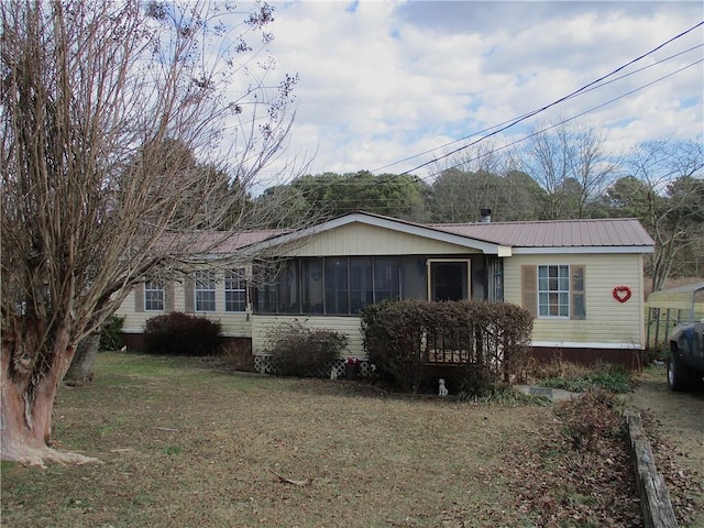 view of side of property featuring a sunroom and a lawn