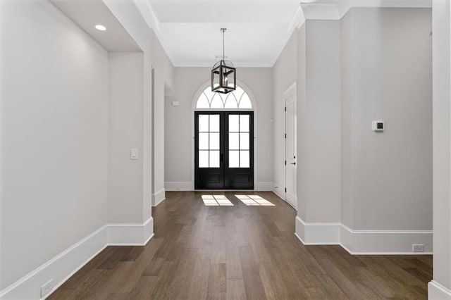 entryway featuring french doors, dark hardwood / wood-style floors, and ornamental molding