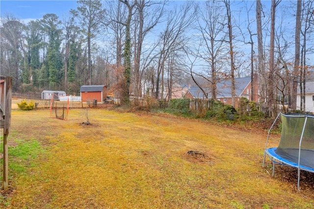 view of yard with a trampoline and a storage unit