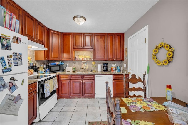 kitchen with light tile patterned floors, white appliances, sink, backsplash, and light stone counters