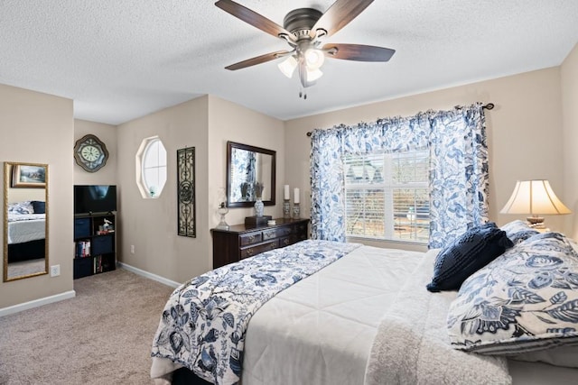 bedroom with ceiling fan, multiple windows, light carpet, and a textured ceiling