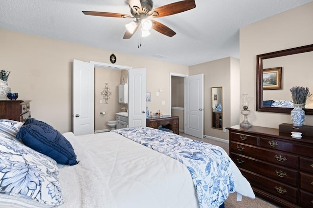 carpeted bedroom featuring ceiling fan and ensuite bath