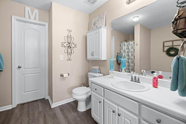 bathroom with toilet, vanity, wood-type flooring, and a textured ceiling