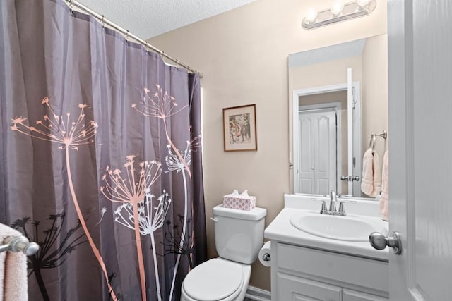 bathroom featuring toilet, vanity, and a textured ceiling