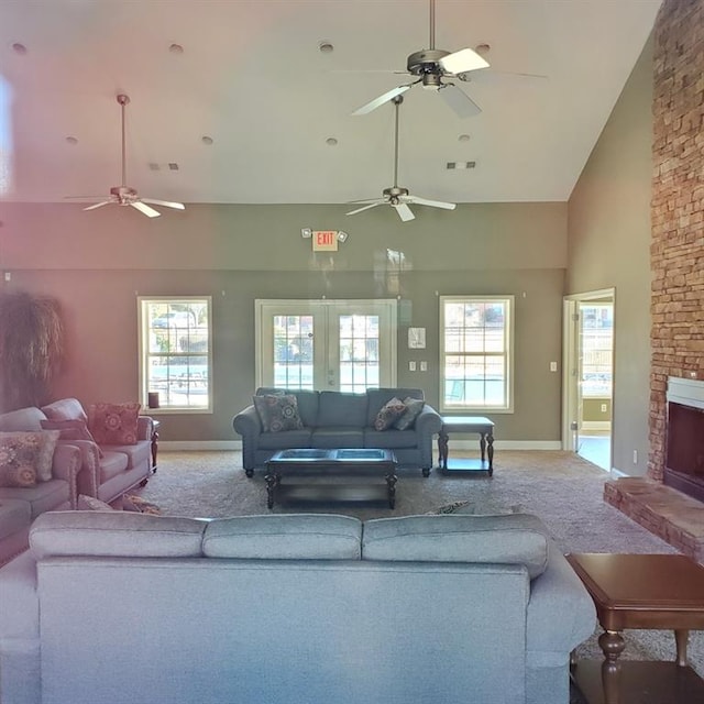 carpeted living room featuring french doors, a fireplace, plenty of natural light, and high vaulted ceiling