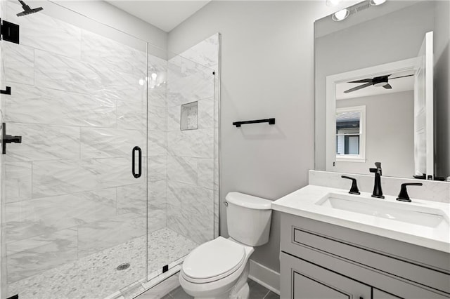 bathroom featuring vanity, toilet, ceiling fan, and a shower with shower door