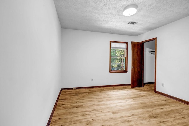 2775 Doaks Run Ct, Tucker, GA 30084 - unfurnished bedroom featuring wood finished floors, a textured ceiling, and a walk in closet