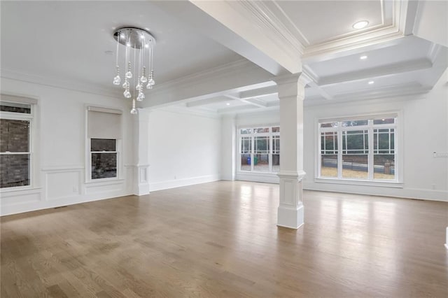 unfurnished living room with beamed ceiling, ornamental molding, and decorative columns