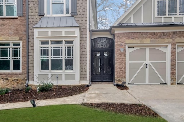 doorway to property with metal roof, concrete driveway, and a standing seam roof