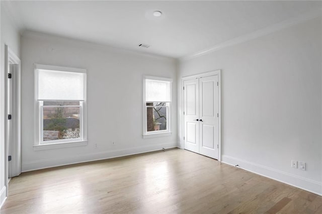 empty room featuring baseboards, wood finished floors, and ornamental molding