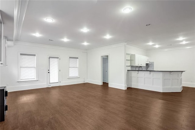 unfurnished living room featuring dark wood finished floors, baseboards, and ornamental molding