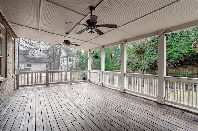 wooden terrace featuring ceiling fan and fence