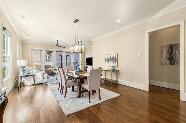 dining area with a notable chandelier, wood finished floors, visible vents, baseboards, and crown molding