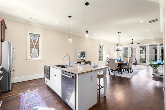 kitchen featuring stainless steel appliances, a sink, visible vents, dark wood-style floors, and crown molding