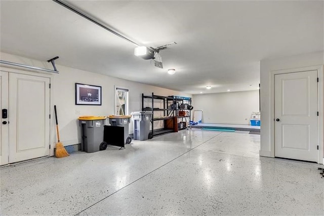 garage featuring a garage door opener and baseboards