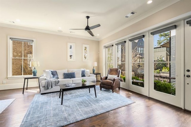 living area featuring recessed lighting, visible vents, crown molding, and wood finished floors