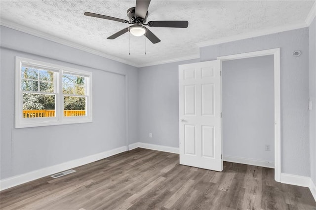 unfurnished bedroom featuring visible vents, wood finished floors, and ornamental molding