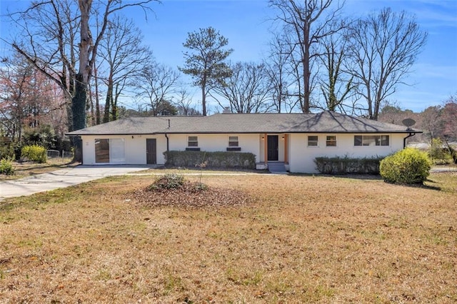 ranch-style home with a front lawn, a garage, and driveway