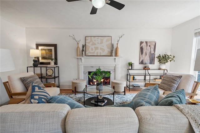 living room featuring baseboards, a ceiling fan, wood finished floors, and a high end fireplace