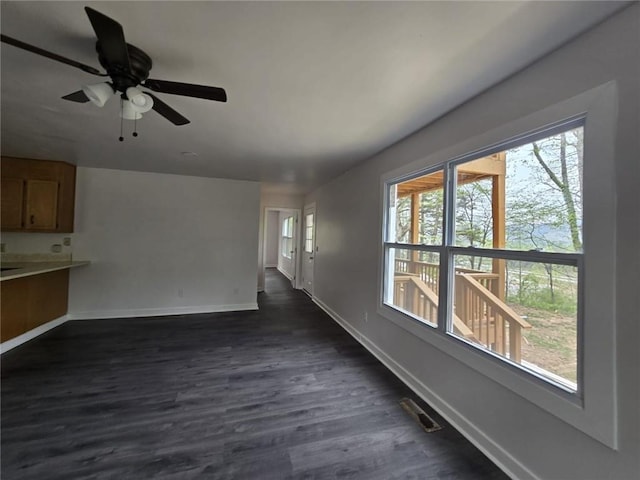 unfurnished living room with ceiling fan and dark hardwood / wood-style flooring