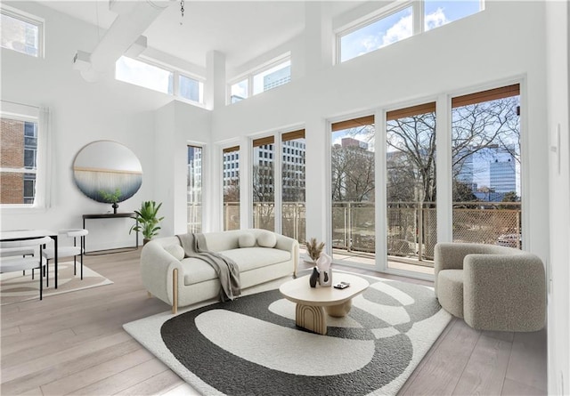 living room featuring light hardwood / wood-style floors and a towering ceiling