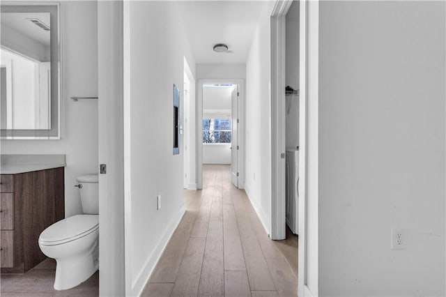 corridor with light hardwood / wood-style flooring