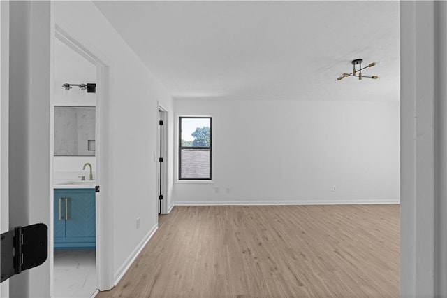 spare room featuring light wood-type flooring and sink