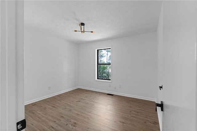 empty room featuring hardwood / wood-style floors and a textured ceiling