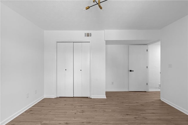 unfurnished bedroom with light wood-type flooring and a closet