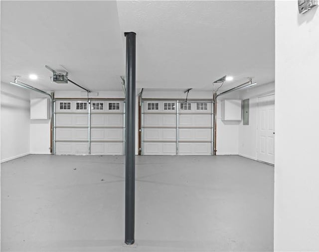 garage with a garage door opener and electric panel