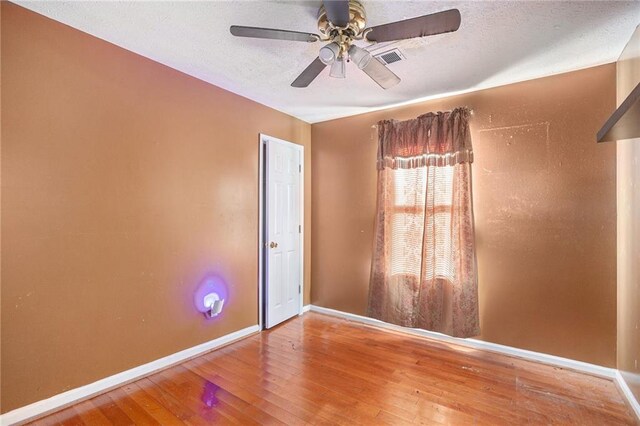 empty room with ceiling fan and wood-type flooring