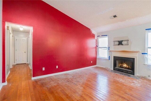 unfurnished living room with hardwood / wood-style flooring and a healthy amount of sunlight