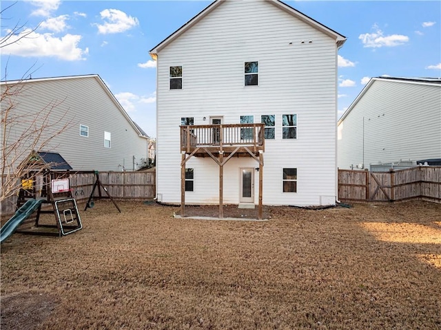 rear view of property with a lawn and a playground