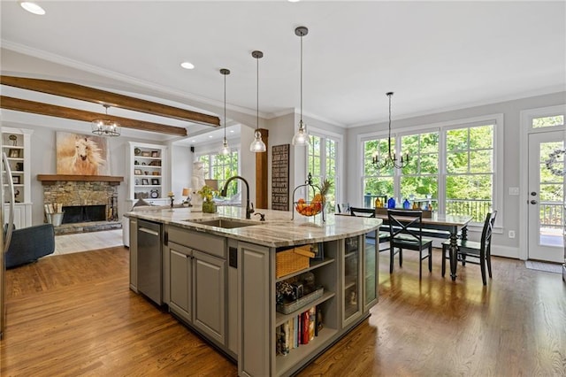 kitchen featuring a sink, an inviting chandelier, gray cabinetry, open shelves, and a fireplace