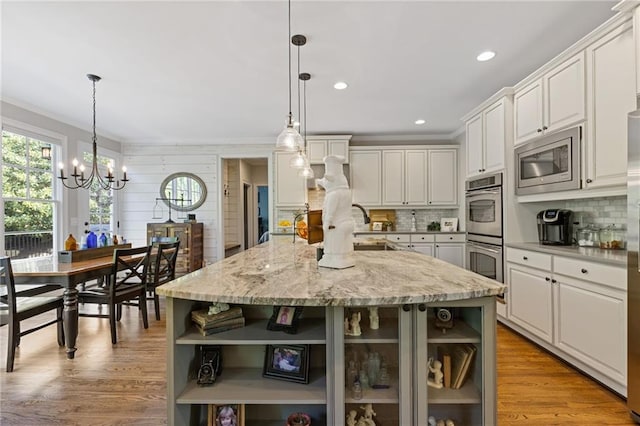 kitchen featuring open shelves, tasteful backsplash, stainless steel appliances, and an inviting chandelier