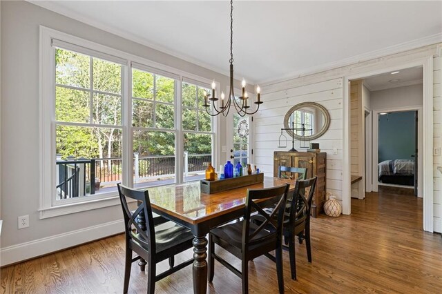 dining area with a wealth of natural light, a notable chandelier, and crown molding