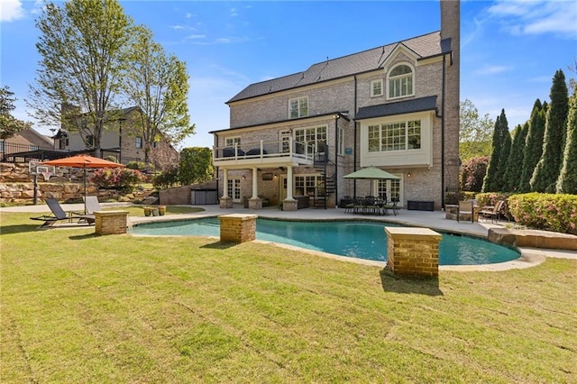 back of house with a yard, a patio, and an outdoor pool