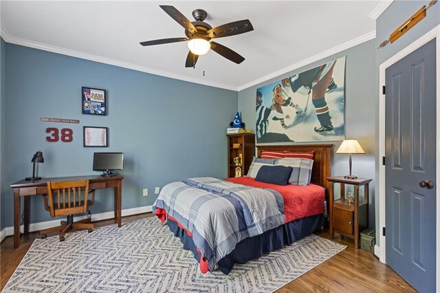 bedroom with baseboards, a ceiling fan, wood finished floors, and crown molding